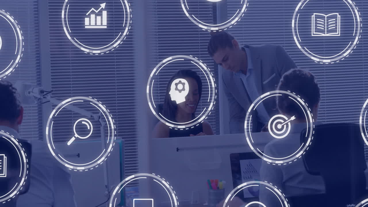 Animation of business icons over diverse business people discussing work