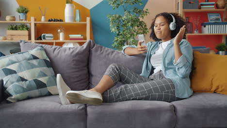 young woman enjoying music on a couch