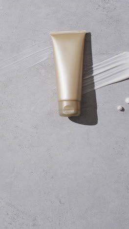 vertical video of beauty product tube and cream smudge with copy space on white background
