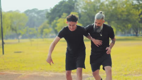two men playing basketball in a park