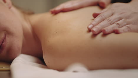 la masajista está frotando y masajeando el cuerpo de la cliente femenina en el salón de spa relajarse y rehabilitarse