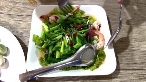 mixing shrimp and vegetables in thai cuisine