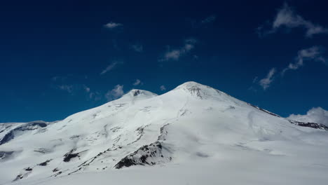 Vuelo-Aéreo-A-Través-De-Una-Hermosa-Vista-Del-Monte-Elbrus,-Montañas-Del-Norte-Del-Cáucaso,-Rusia.-Está-Situado-En-La-Parte-Occidental-Del-Cáucaso-Y-Es-El-Pico-Más-Alto-De-Las-Montañas-Del-Cáucaso.