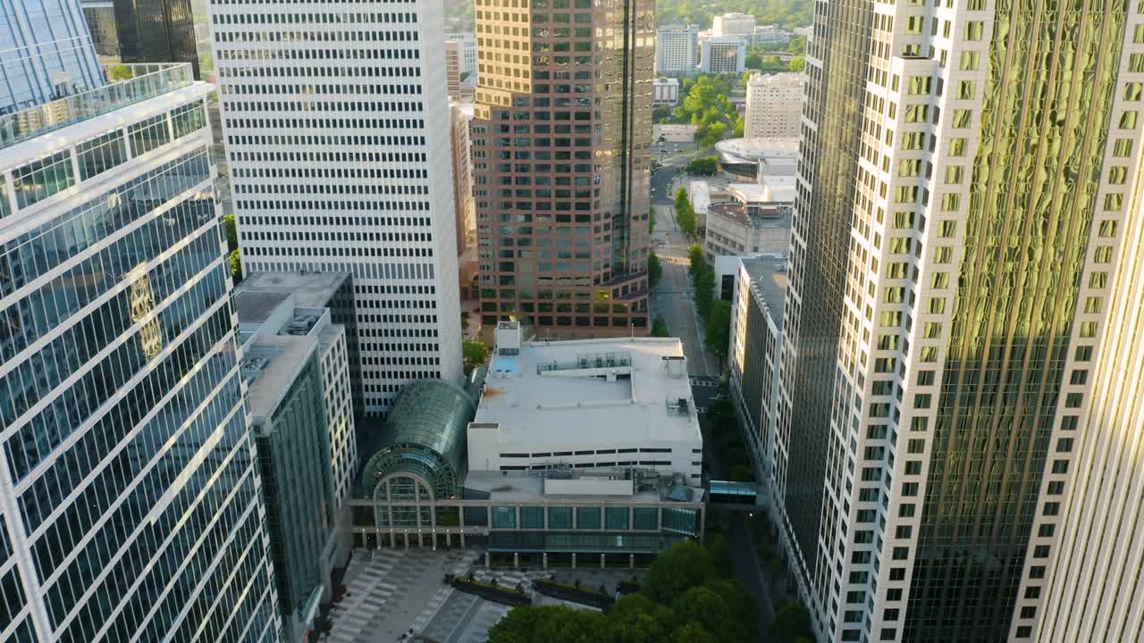 드론은 해가 뜰 때 알아볼 수 없는 도시의 현대적인 고층 빌딩 사이를 날아다닌다