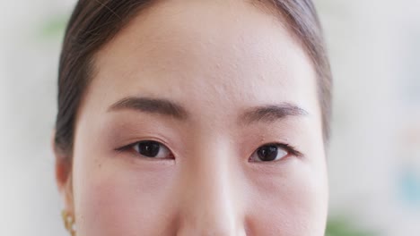 video close up portrait of the opening and smiling eyes of asian female doctor in hospital