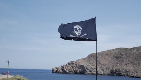 pirate flag waving by the sea in fornells, menorca, evoking adventure and mystery