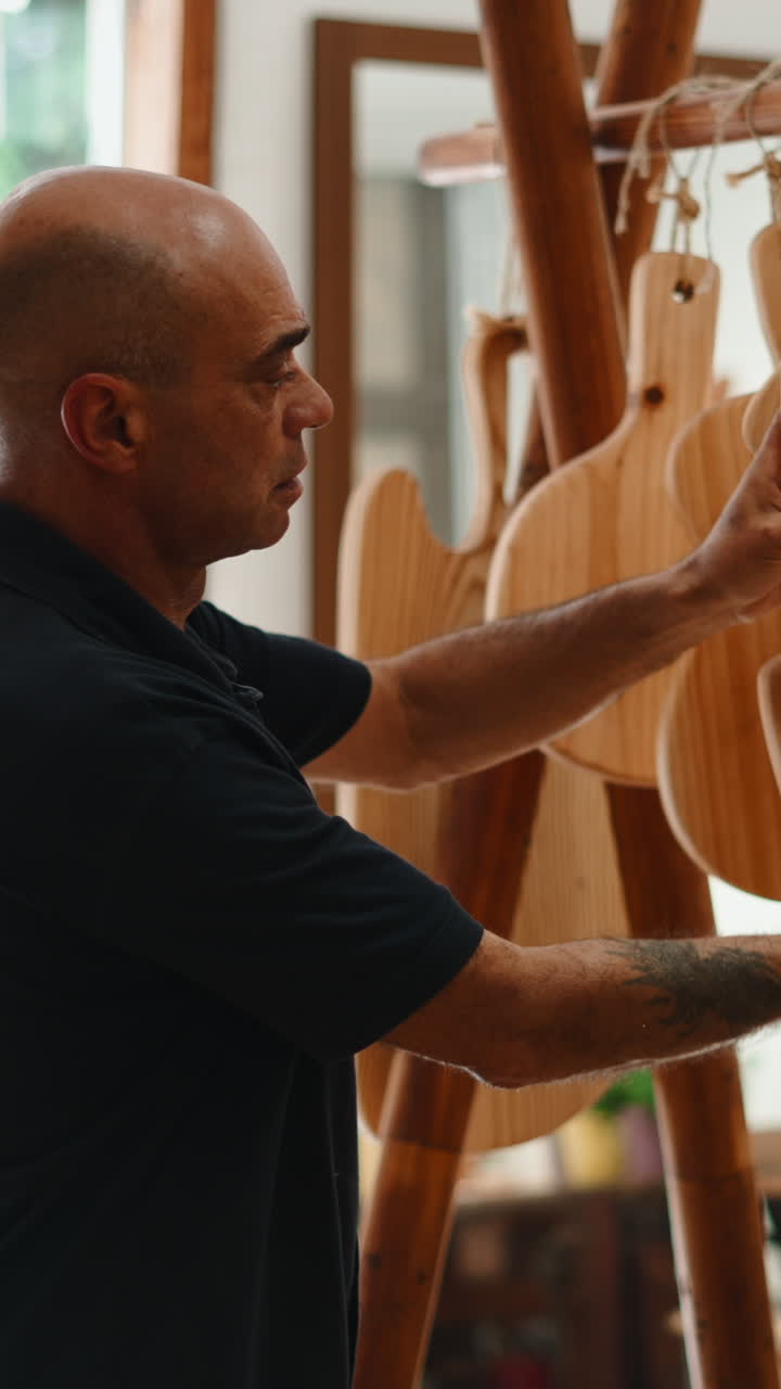 Craftsman Inspecting Handmade Wooden Guitar-Shaped Cutting Boards