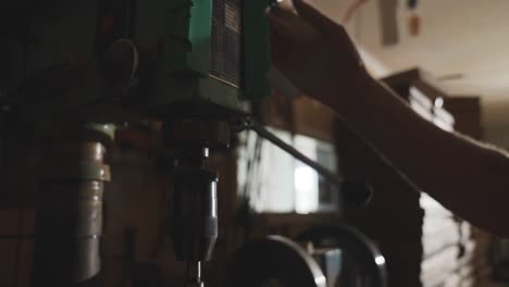 craftsman using speed handle on milling machine in workshop, up and down