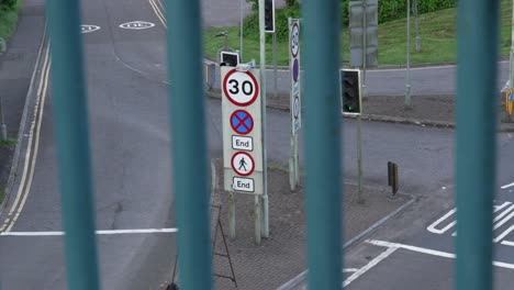 Señal-De-30-Millas-Por-Hora-En-La-Autovía-Con-Un-Camión-Que-Pasa-Temprano-En-La-Mañana-Con-Semáforo-En-Gales,-Reino-Unido