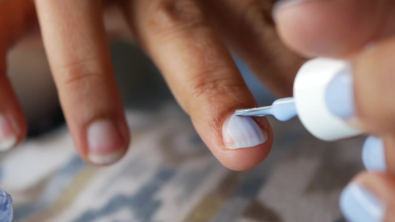 Primo Piano di Mano che Applica Smalto Azzurro
