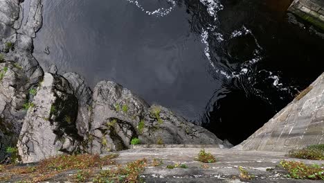 water flows beneath a stone bridge in llangollen