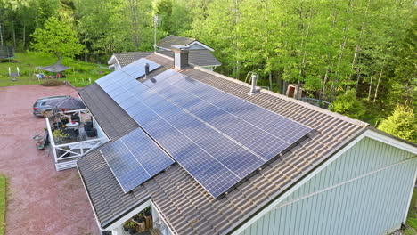 Módulos-Aéreos-De-Luz-Solar-Que-Cubren-El-Techo-De-Una-Casa-De-Madera,-Carga-De-Vehículos-Eléctricos-En-El-Patio