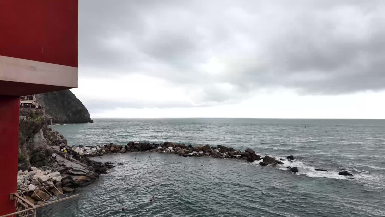 이탈리아의 리오마지오레 마을에서 은 집 너머의 바다는 평온한 해안의 아름다움을 포착합니다.