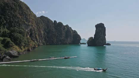 Aerial-shot-of-local-boats-departing-from-Pai-Plong-Beach-with-beautiful-seascape-at-background-in-Krabi,-Thailand