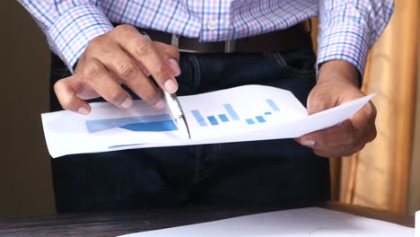 hombre de negocios revisando un documento con gráficos y gráficos