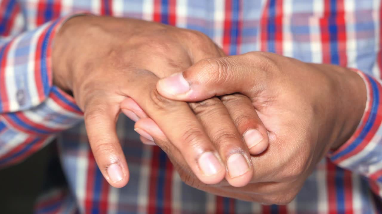 primer plano de las manos de un hombre que muestra posible dolor o lesión