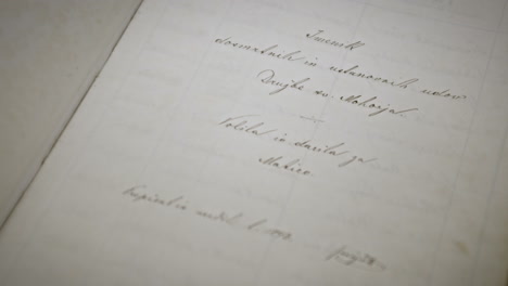 close up of an book, man's hand flips the page, hand writen text