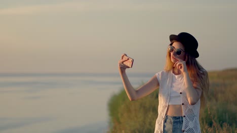 una mujer tomando una selfie al atardecer.