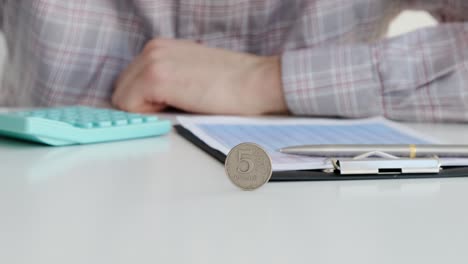 slow motion business man spins a penny on a white table. business concept.