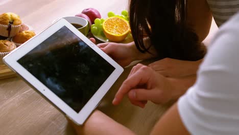 happy couple using tablet and having breakfast