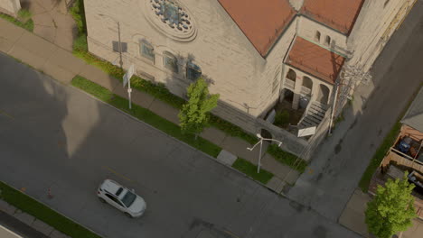 slow descent over a city street and alley with power lines and building rooftop