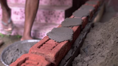 contractor construction site building a wall with brick and concrete close up