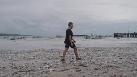 man walking on a polluted beach