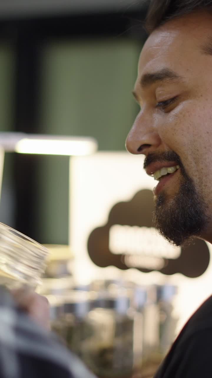 Man inspecting cannabis in a jar