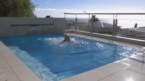 mujer saltando a la piscina completamente vestida