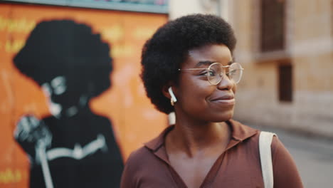 happy african american woman walking on the city