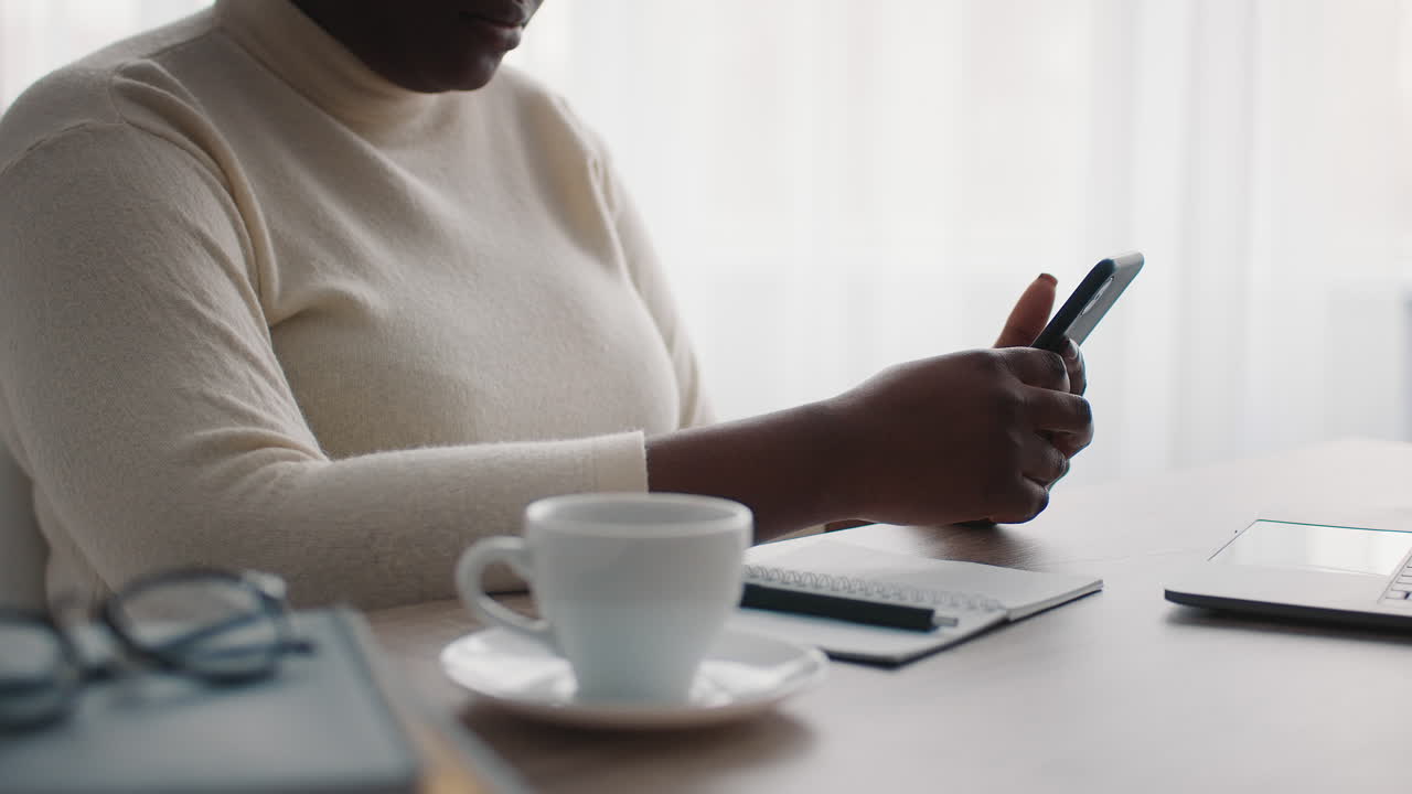 Woman using smartphone at her desk