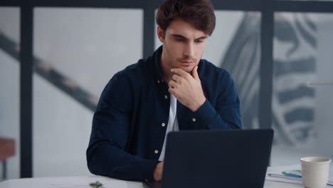 Close-up-view-of-focused-business-man-working-laptop-in-office