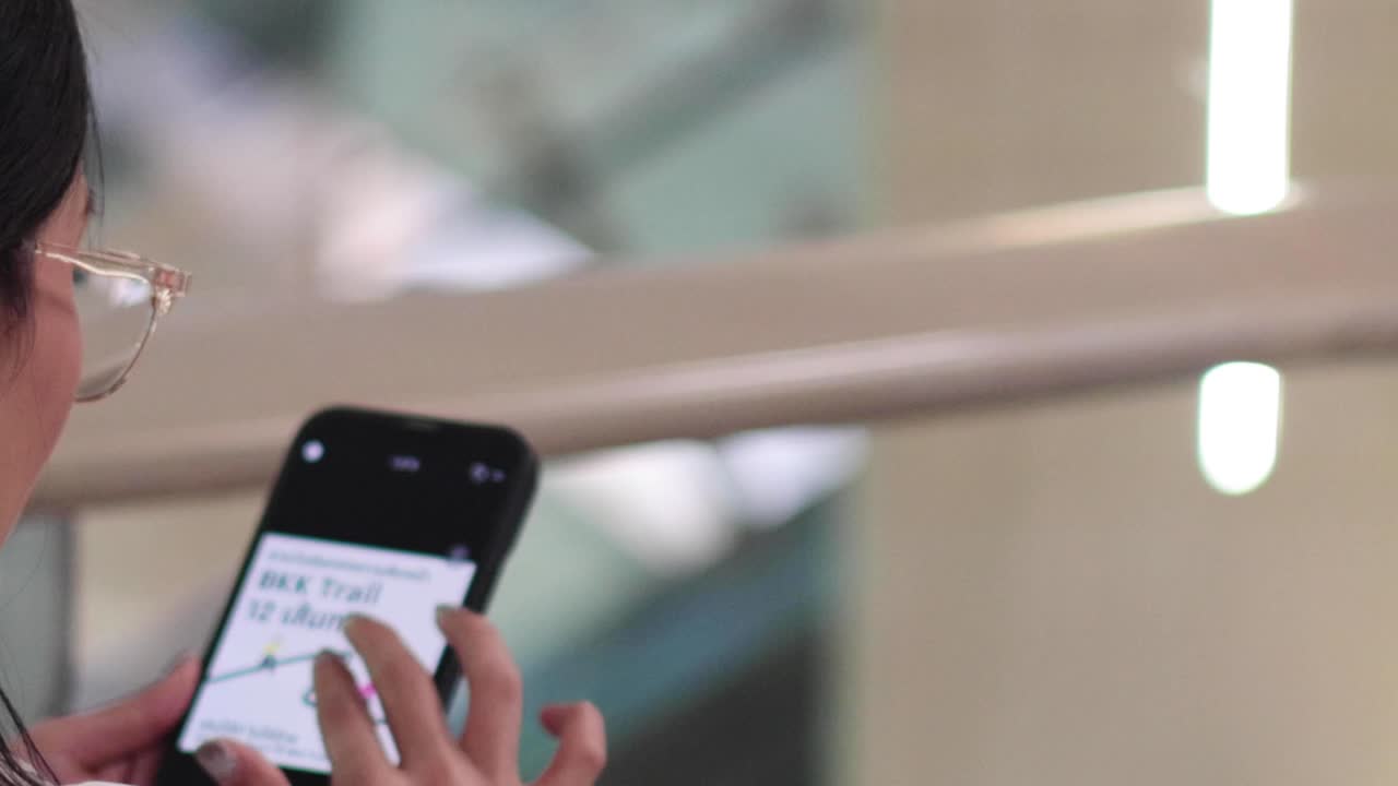 persona que utiliza el teléfono, posiblemente enviando mensajes de texto o navegando