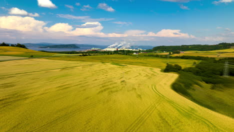 vast landscape of wheat fields with an industrial park in the background in auringan, norway