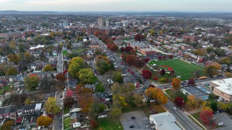 Slow-high-aerial-orbit-showing-skyline-and-outskirts-of-small-city-in-America-during-autumn