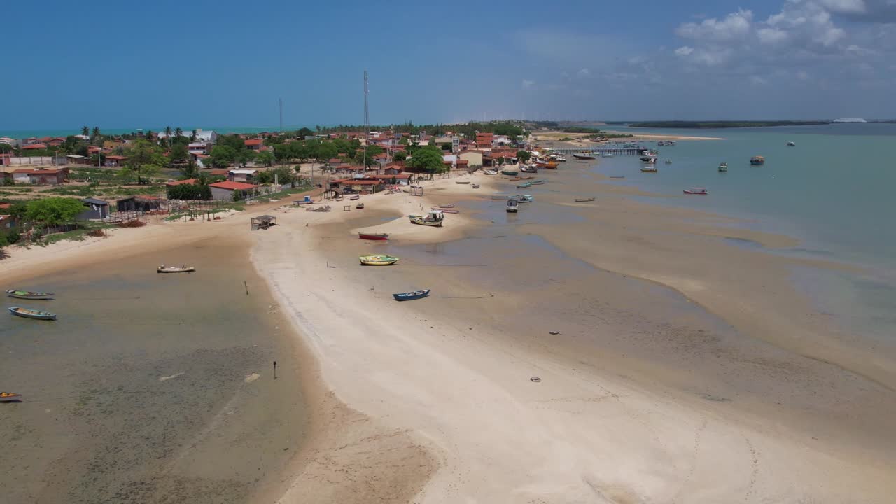 volando sobre una playa de arena con barcos atracados en aguas poco profundas en la isla de natal, brasil
