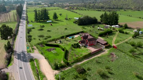 Dolly-in-aerial-view-of-a-house-in-the-middle-of-a-highway-with-nothing-in-the-surrounding-area