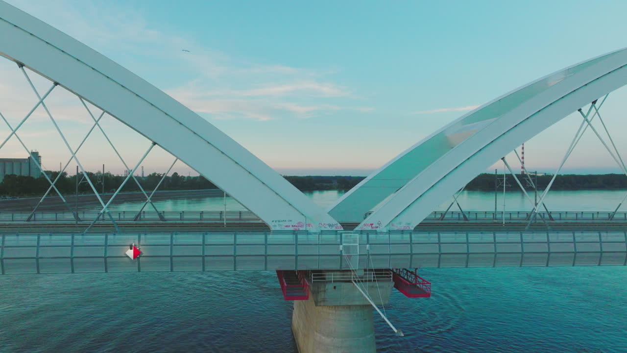 산업 구역과 함께 강을 가로지르는 현대적인 아치 다리