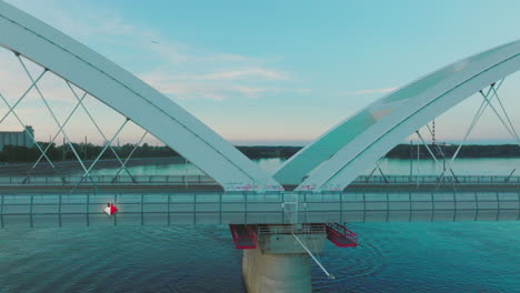 modern arch bridge over river with industrial area