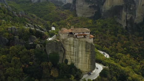 Vista-Aérea-Alrededor-Del-Monasterio-De-Moní-Rousánou,-En-Meteora-Nublada,-Grecia---ángulo-Alto,-órbita,-Disparo-De-Drones