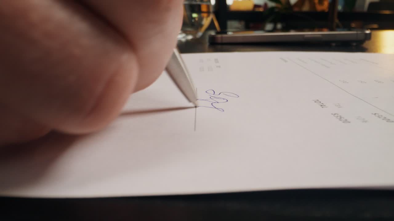 Person signing a receipt or bill at a restaurant