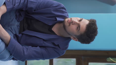 vertical video of stressful and tense sitting by the wall.