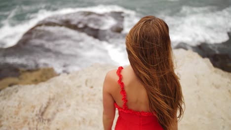 Vista-Trasera-De-Una-Chica-Vestida-De-Rojo-Con-El-Pelo-Largo-Mirando-Las-Olas-Del-Océano---Suburbios-Del-Este,-Sydney,-Nsw,-Australia