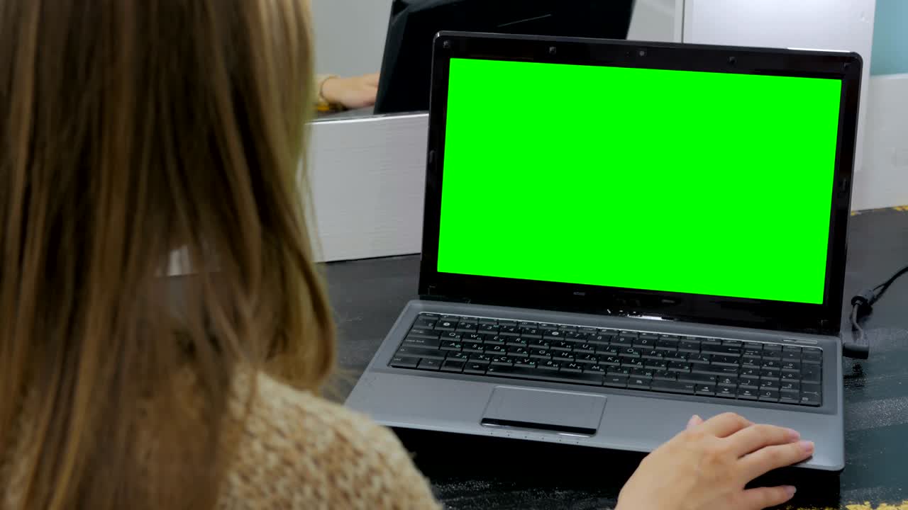 mujer usando una computadora portátil con pantalla verde