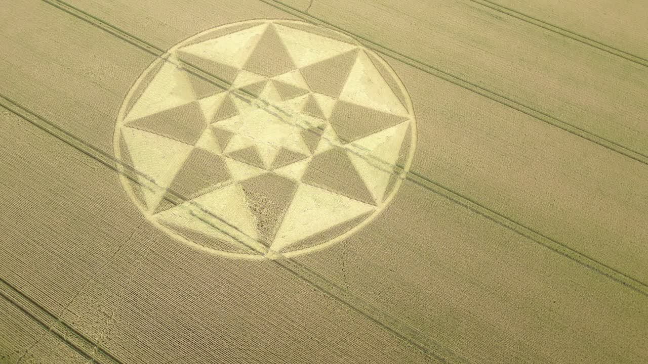 vista aérea giratoria mirando hacia abajo sobre micheldever círculo geométrico de cultivos formado en tierras de cultivo de trigo rurales de hampshire