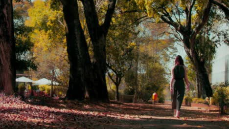 woman in long green dress walking in park on cold autumn morning