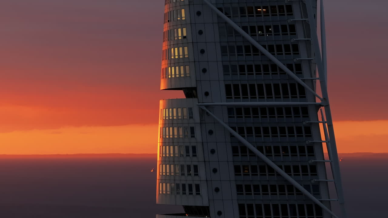 Aerial drone view of Turning Torso residential skyscraper in Malmo, Sweden at sunset