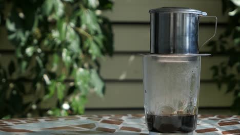 Vietnamese-coffee-dripping-in-glass,-black-coffee-phin-filter