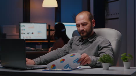 portrait of smiling businessman sitting at desk table analysing financial statistics