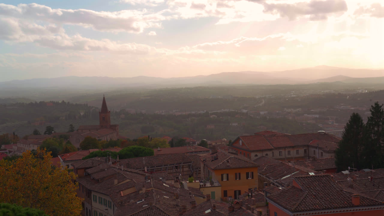 High vantage view of Perugia rooftops and valley landscape under sunset light